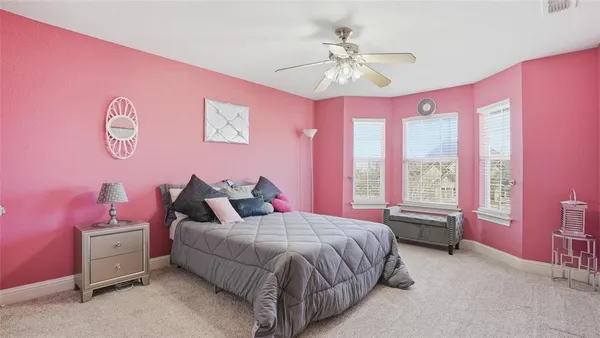 a spacious bedroom with a bed and a chandelier