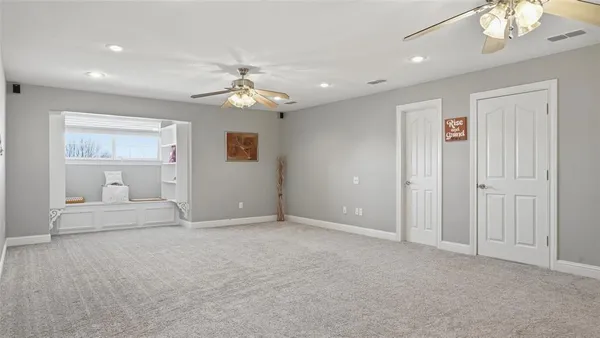 a view of an empty room with a chandelier fan