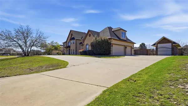 a view of a house with a big yard and large trees
