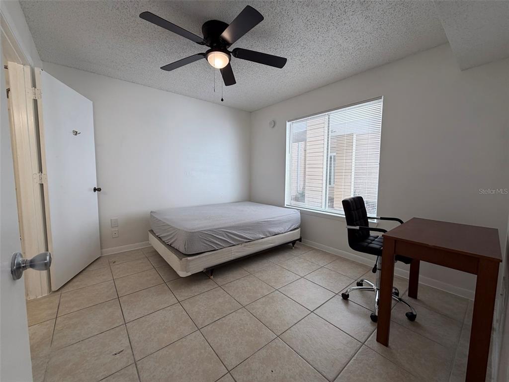 3921 Southwest 34th Street, Unit 301 Gainesville, FL 32608 - Photo 13 of 31 a bedroom with a bed and a desk