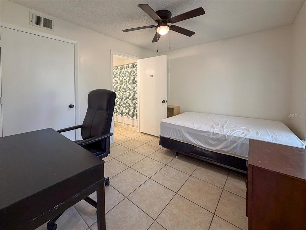 3921 Southwest 34th Street, Unit 301 Gainesville, FL 32608 - Photo 19 of 31 a bedroom with a bed and a desk
