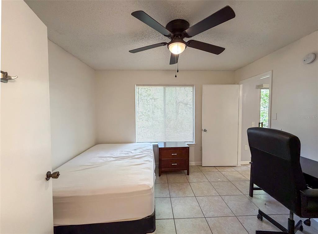 3921 Southwest 34th Street, Unit 301 Gainesville, FL 32608 - Photo 21 of 31 a bedroom with a bed and a chair