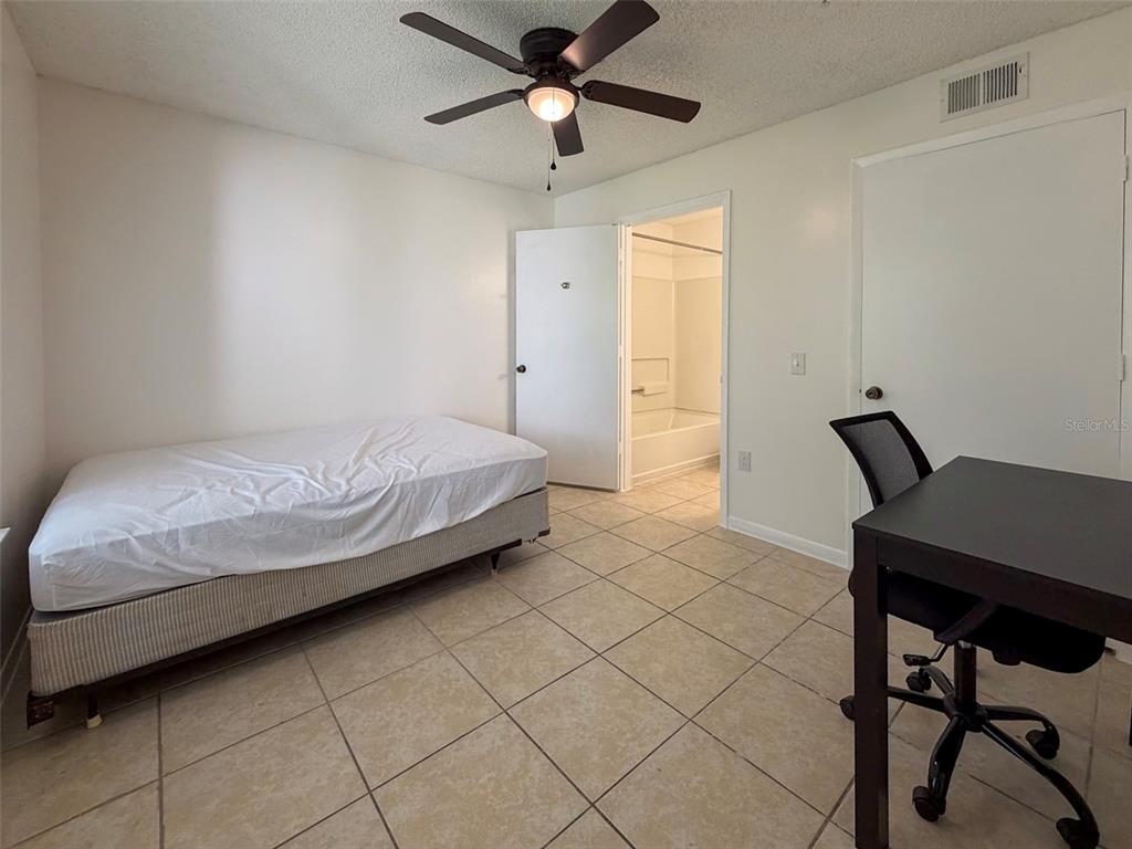 3921 Southwest 34th Street, Unit 301 Gainesville, FL 32608 - Photo 23 of 31 a bedroom with a bed and a desk