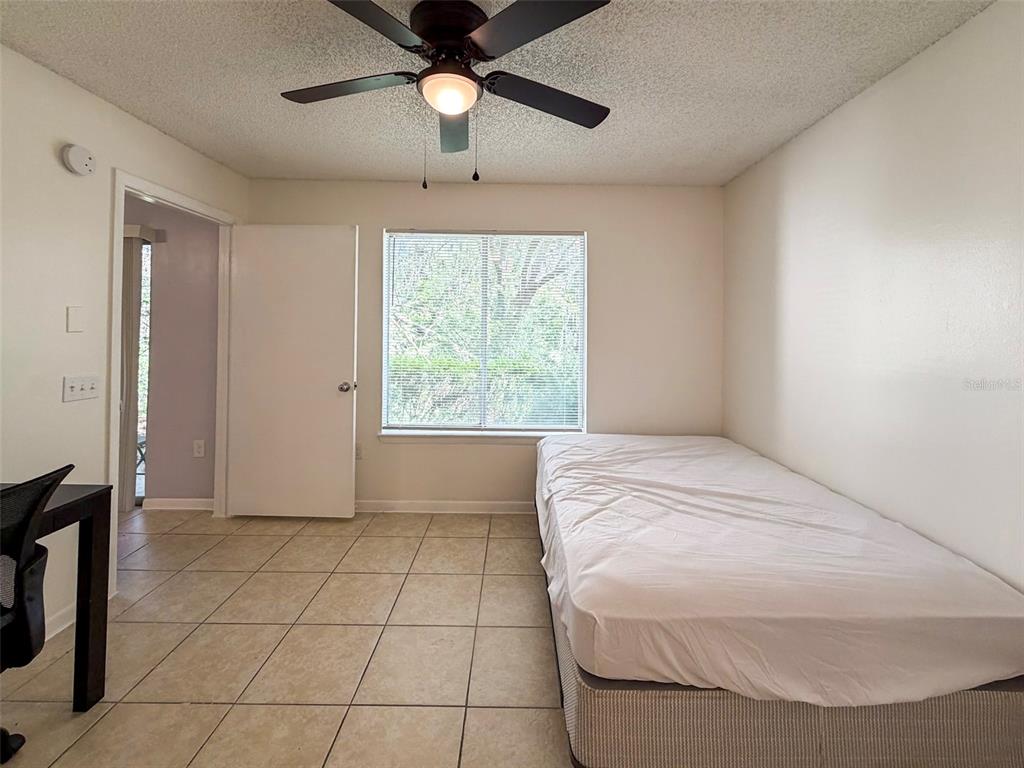 3921 Southwest 34th Street, Unit 301 Gainesville, FL 32608 - Photo 25 of 31 a spacious bedroom with a bed and a chandelier
