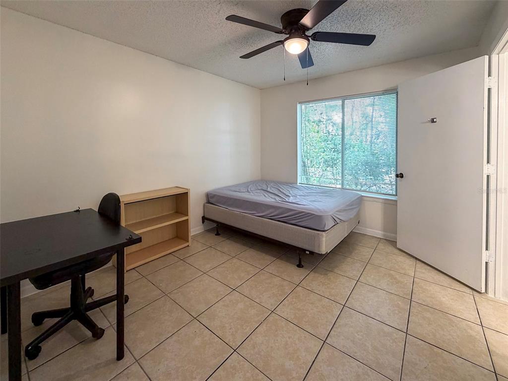 3921 Southwest 34th Street, Unit 301 Gainesville, FL 32608 - Photo 7 of 31 a bedroom with a bed and a desk