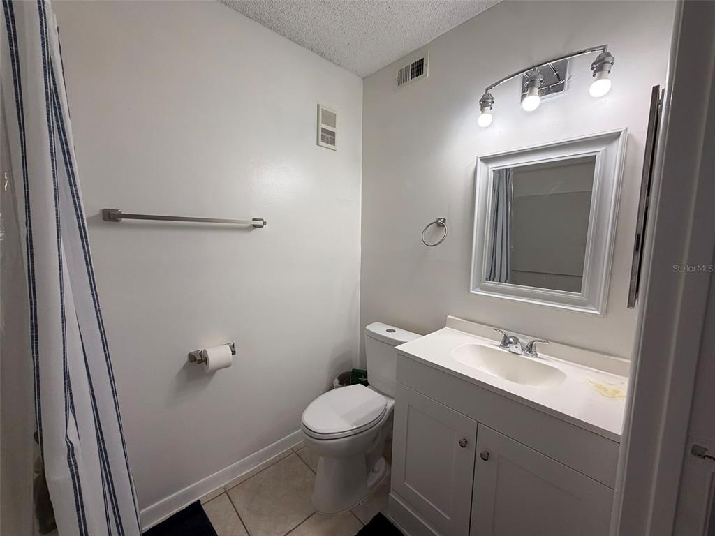 3921 Southwest 34th Street, Unit 301 Gainesville, FL 32608 - Photo 8 of 31 a bathroom with a toilet a sink a mirror and vanity