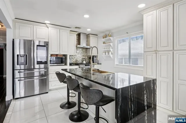 a kitchen with stainless steel appliances granite countertop a sink and a refrigerator