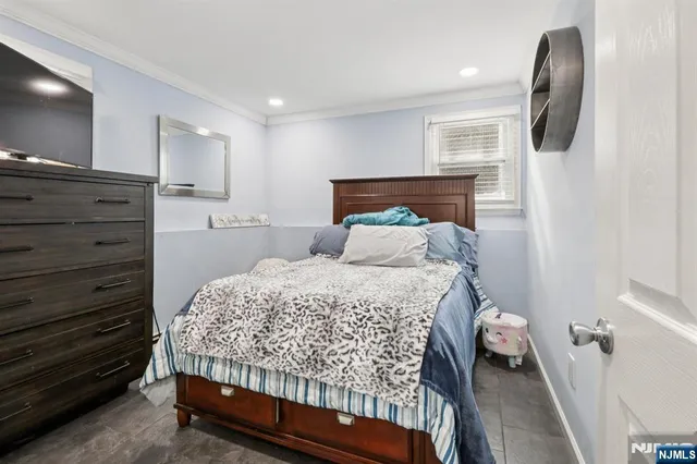 a bedroom with a large bed and a flat tv screen on dresser