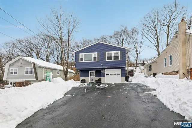 a view of a house with a yard covered in snow