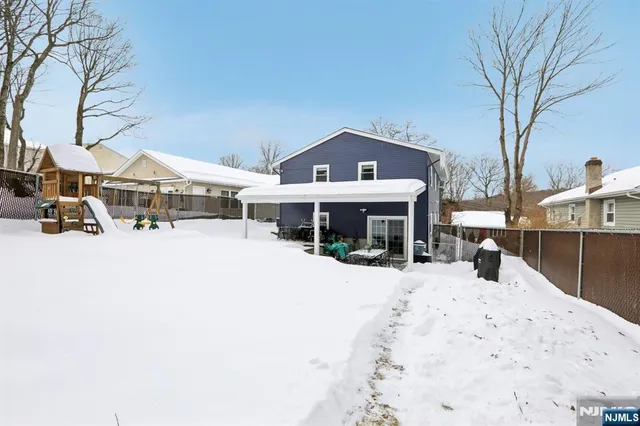 a front view of a house with large trees