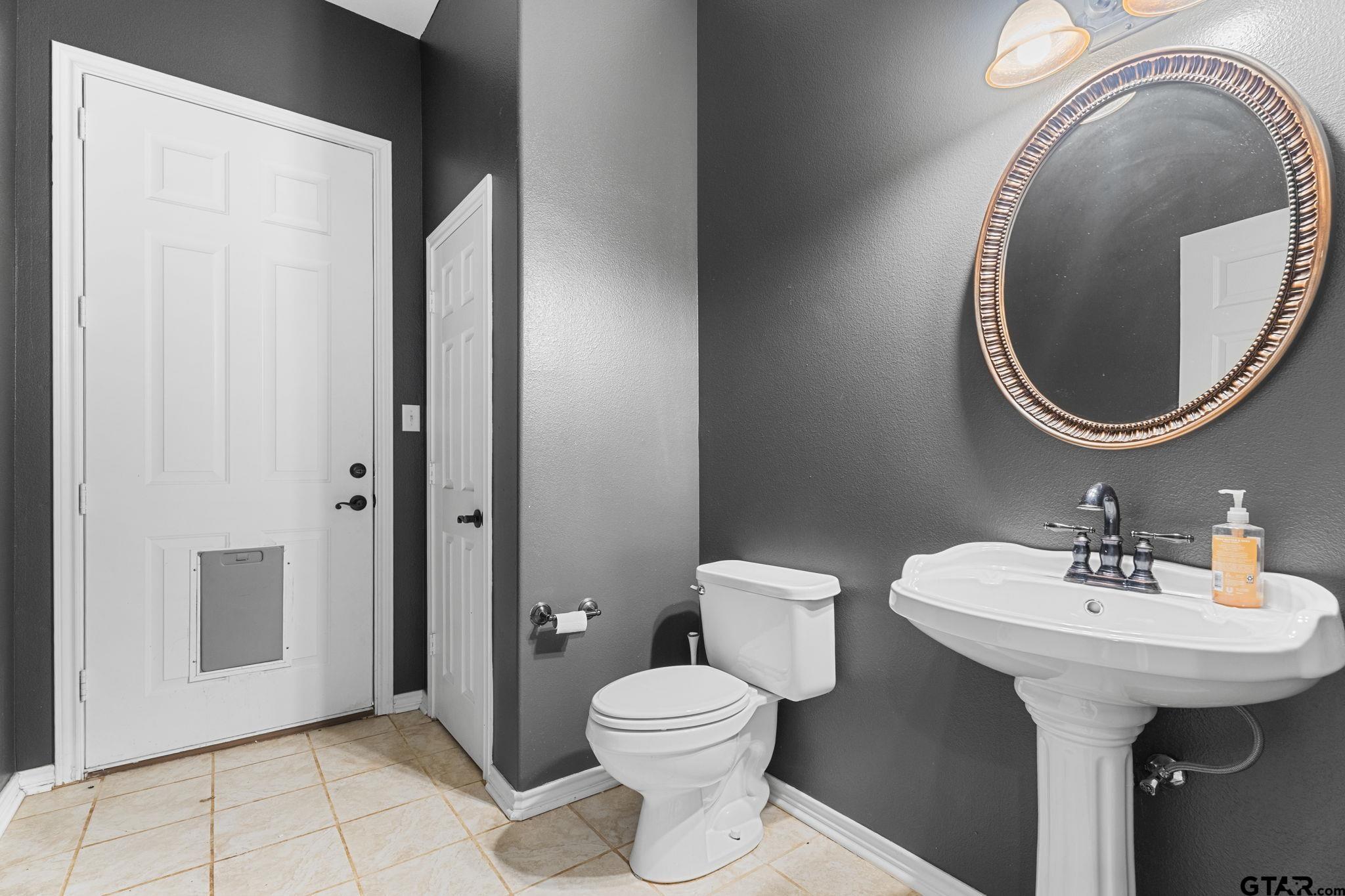 7031 Ridge Pl Circle Tyler, TX 75703 - Photo 19 of 27 a bathroom with a sink and mirror