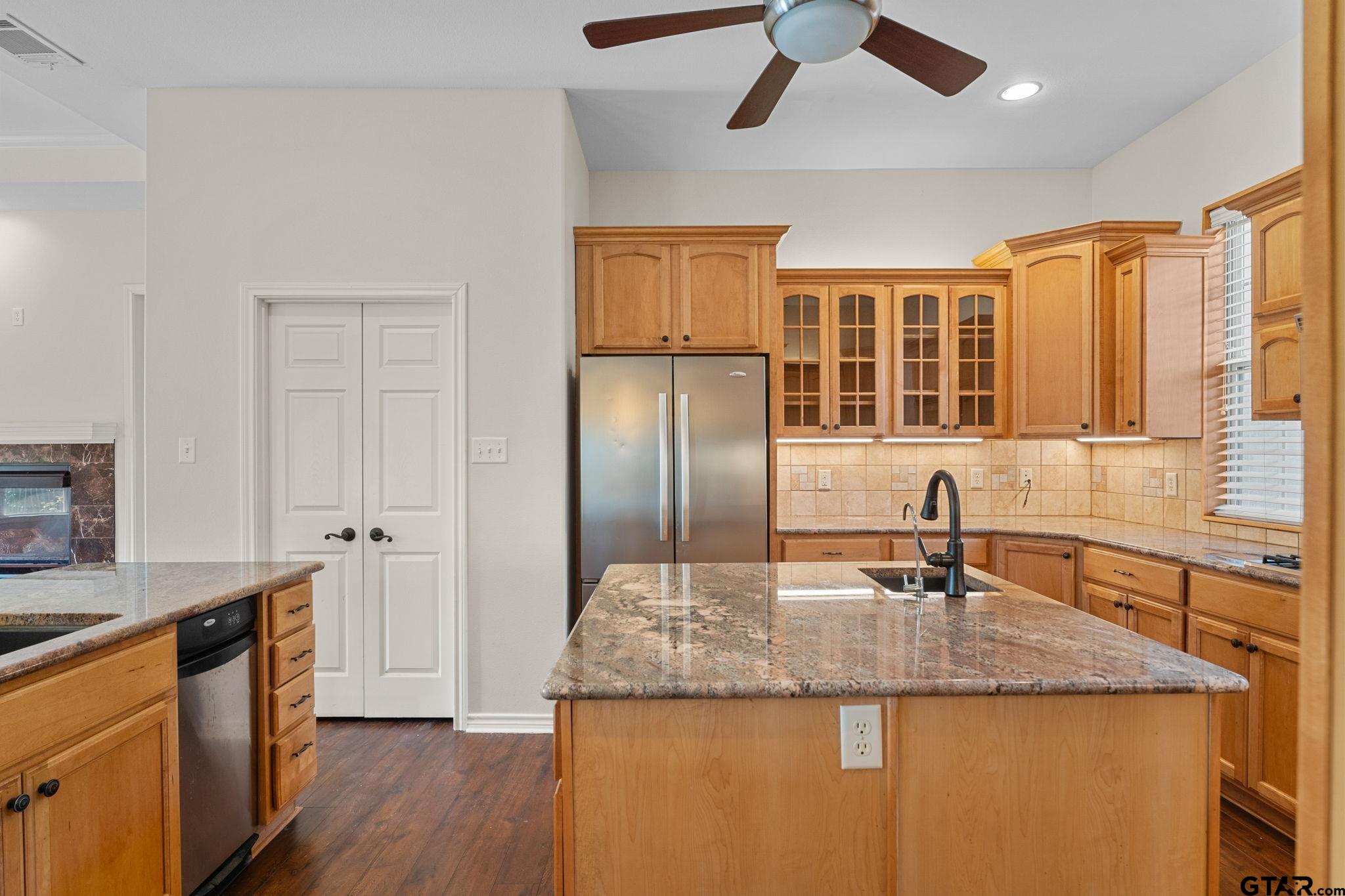 7031 Ridge Pl Circle Tyler, TX 75703 - Photo 5 of 27 a kitchen with stainless steel appliances granite countertop a sink and dishwasher refrigerator a microwave with wooden floor
