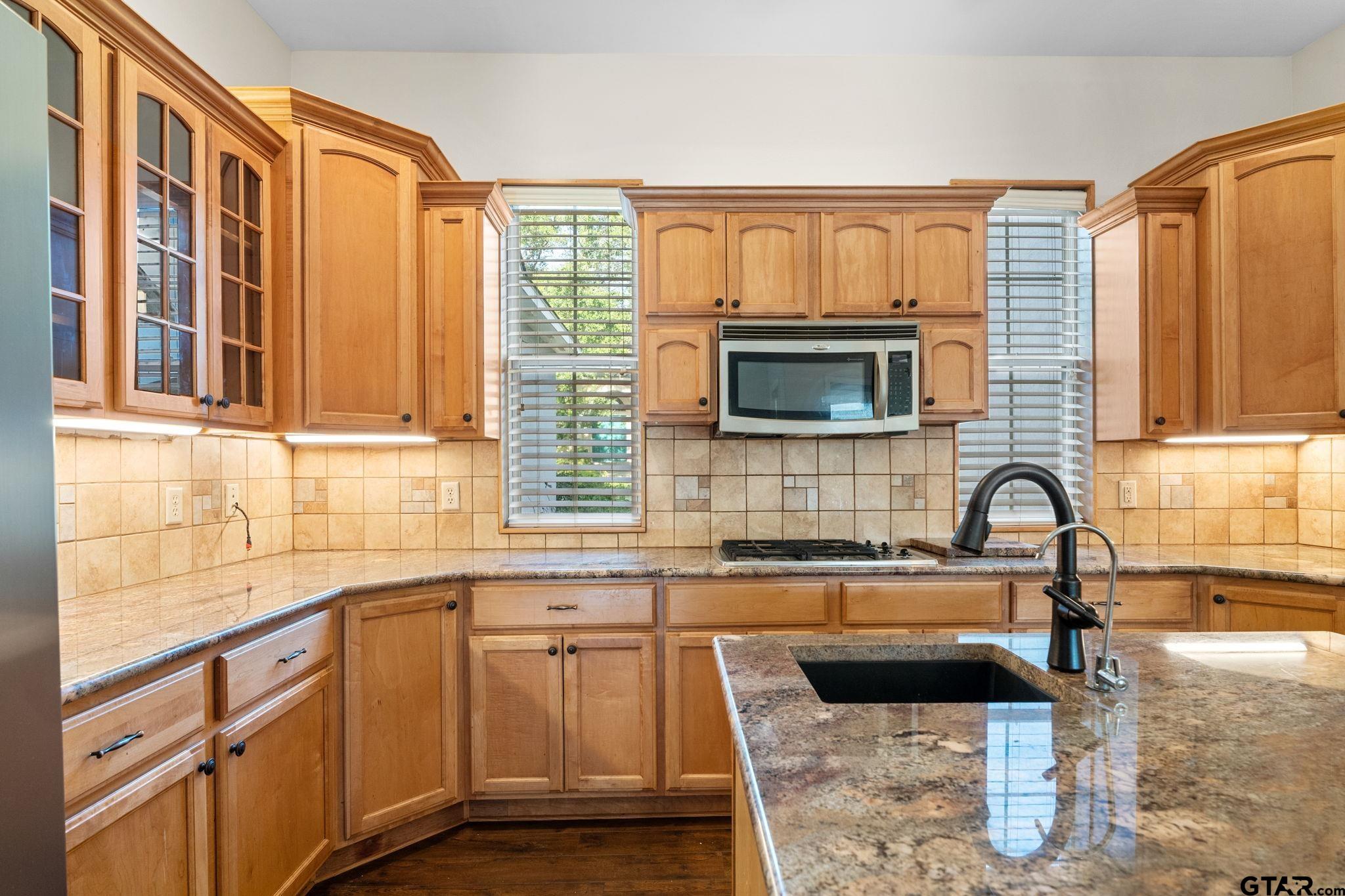 7031 Ridge Pl Circle Tyler, TX 75703 - Photo 6 of 27 a kitchen with granite countertop a sink and a stove top oven