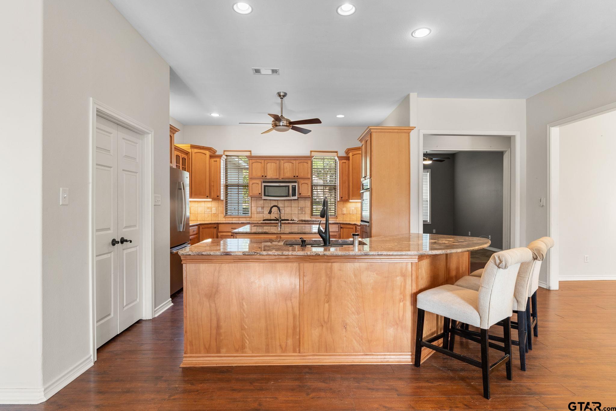 7031 Ridge Pl Circle Tyler, TX 75703 - Photo 7 of 27 a living room with stainless steel appliances granite countertop furniture and wooden floor
