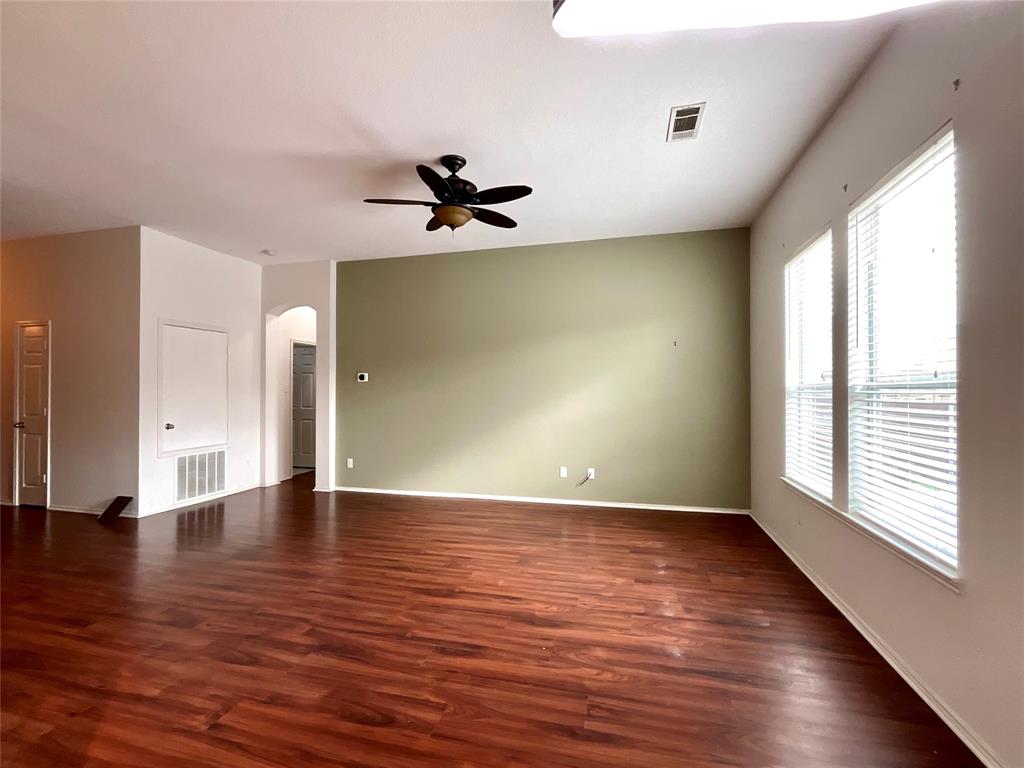 14044 Fontana Road Roanoke, TX 76262 - Photo 4 of 14 Wood-finish flooring, accent wall, ceiling fan, multiple windows, and an arched doorway