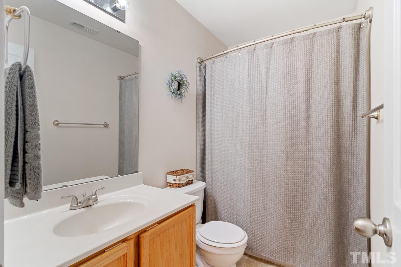 32 Brafferton Court Durham, NC 27713 - Photo 22 of 32 a bathroom with a sink a toilet and shower curtain