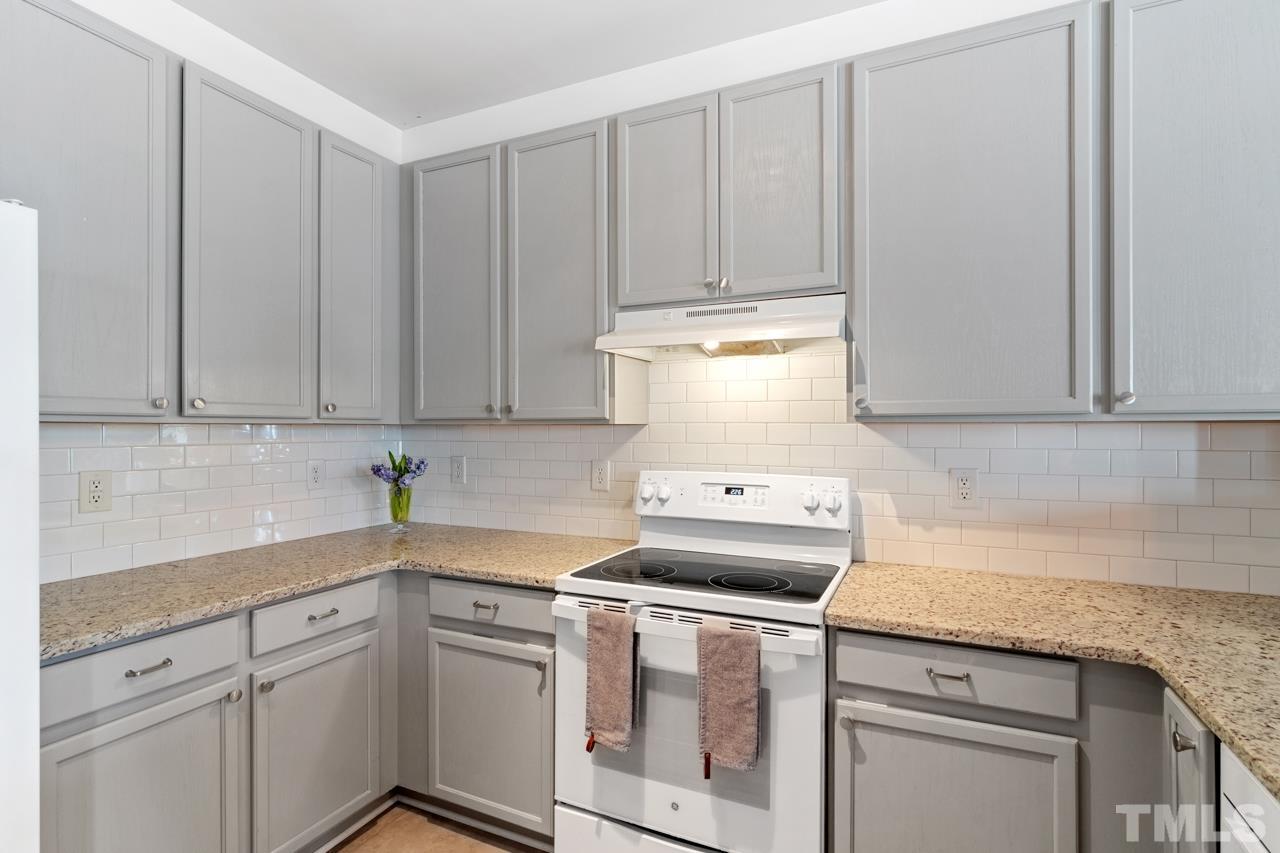 32 Brafferton Court Durham, NC 27713 - Photo 9 of 32 a kitchen with granite countertop white cabinets and white appliances