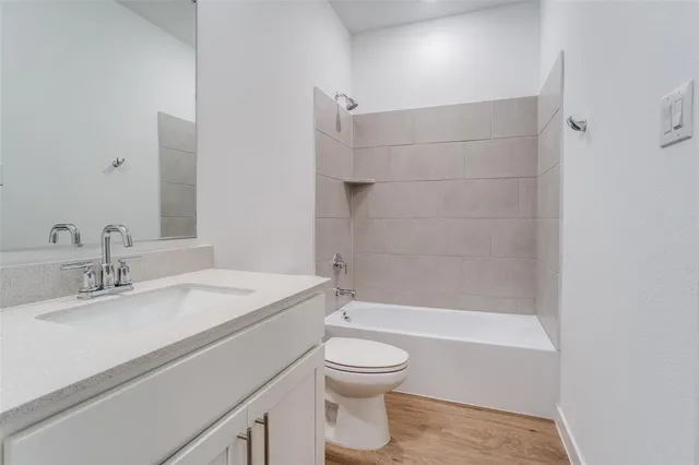 a bathroom with a granite countertop sink toilet a mirror and shower
