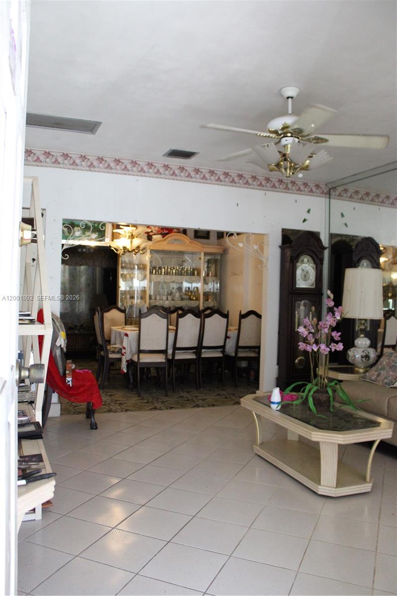 111 Northwest 52nd Street Miami, FL 33127 - Photo 8 of 14 a living room with furniture a chandelier and a floor to ceiling window