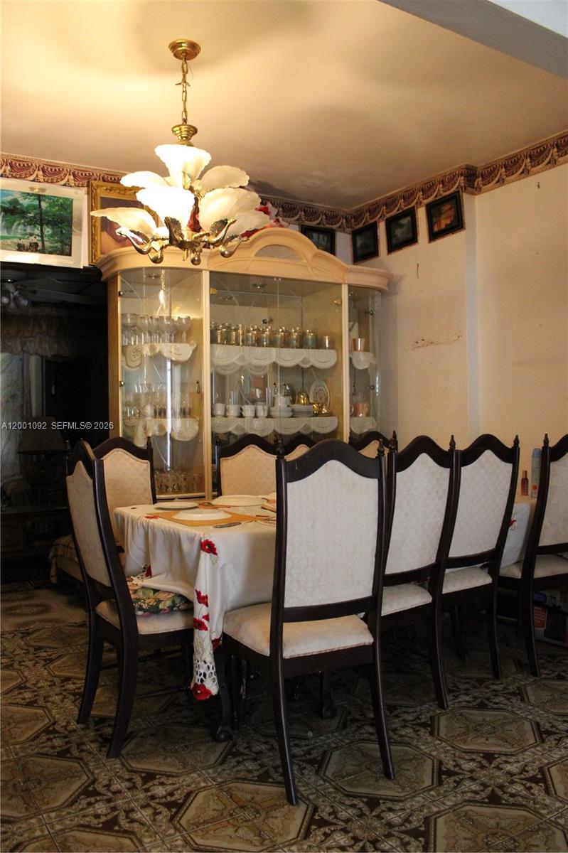 111 Northwest 52nd Street Miami, FL 33127 - Photo 9 of 14 a view of a dining room with furniture wooden floor and chandelier