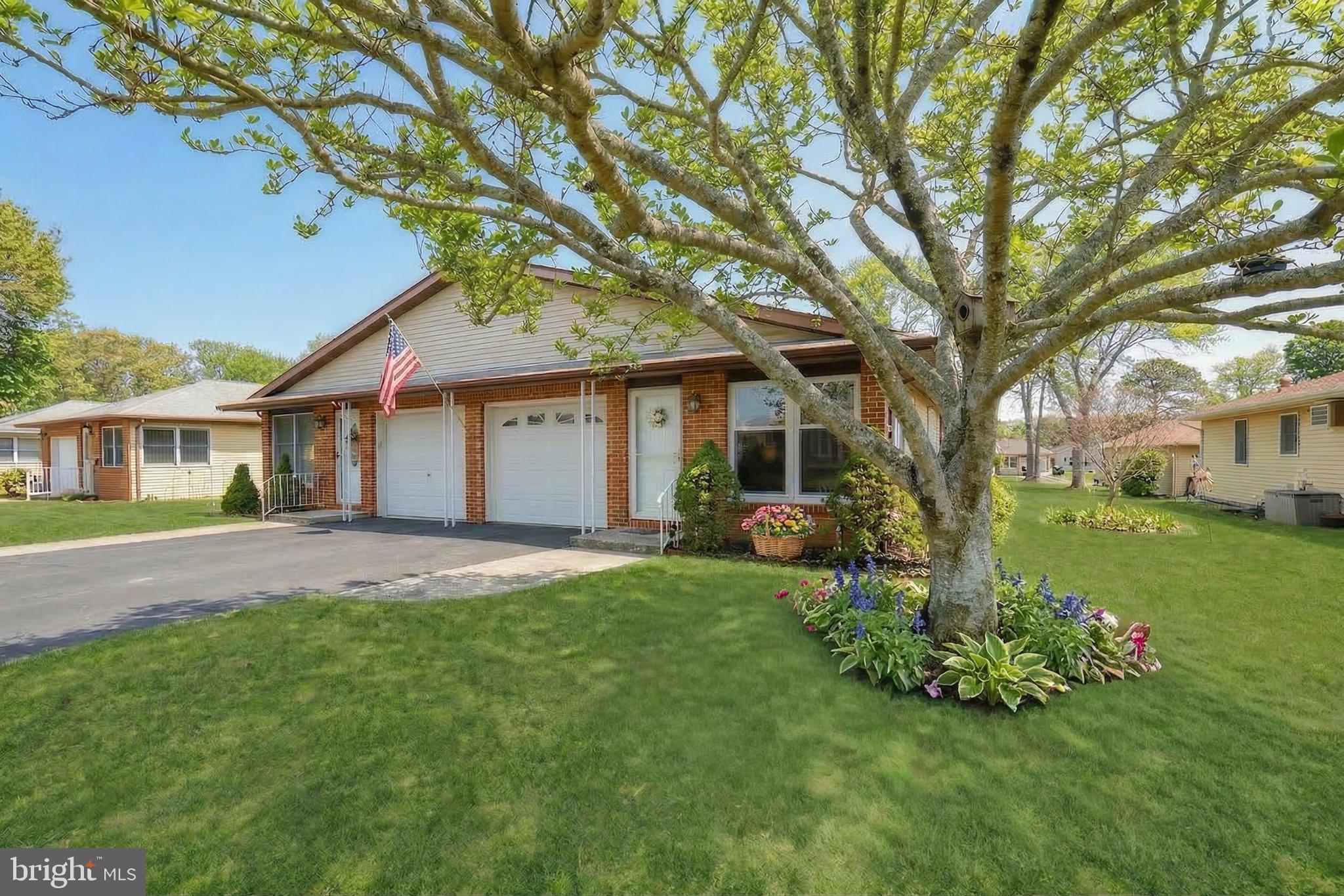 a front view of a house with a garden and trees