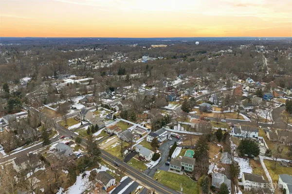 an aerial view of residential houses with city and mountain view in back