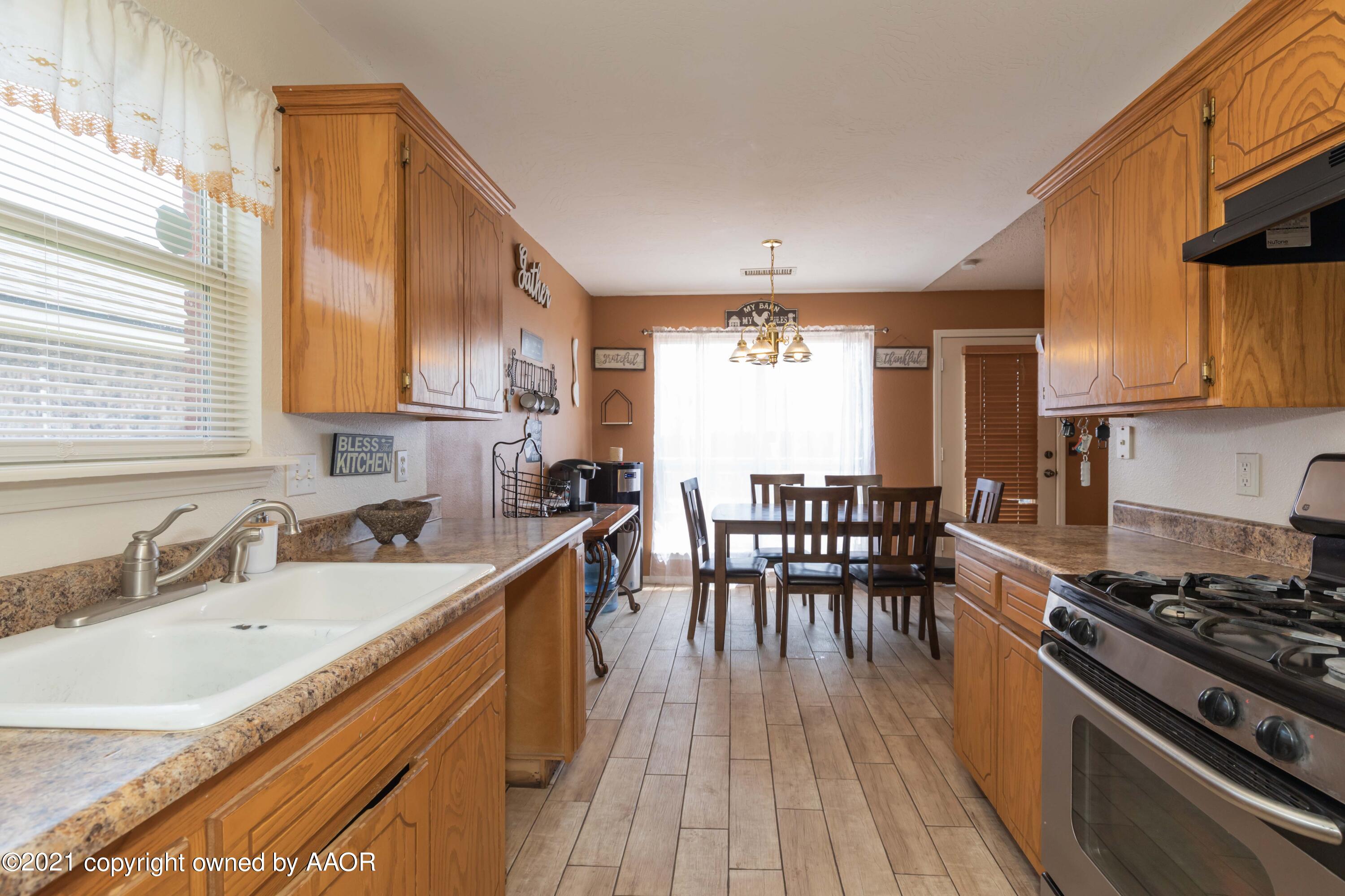 1025 Ketler Street Amarillo, TX 79104 - Photo 11 of 31 a kitchen with wooden cabinets sink and stove