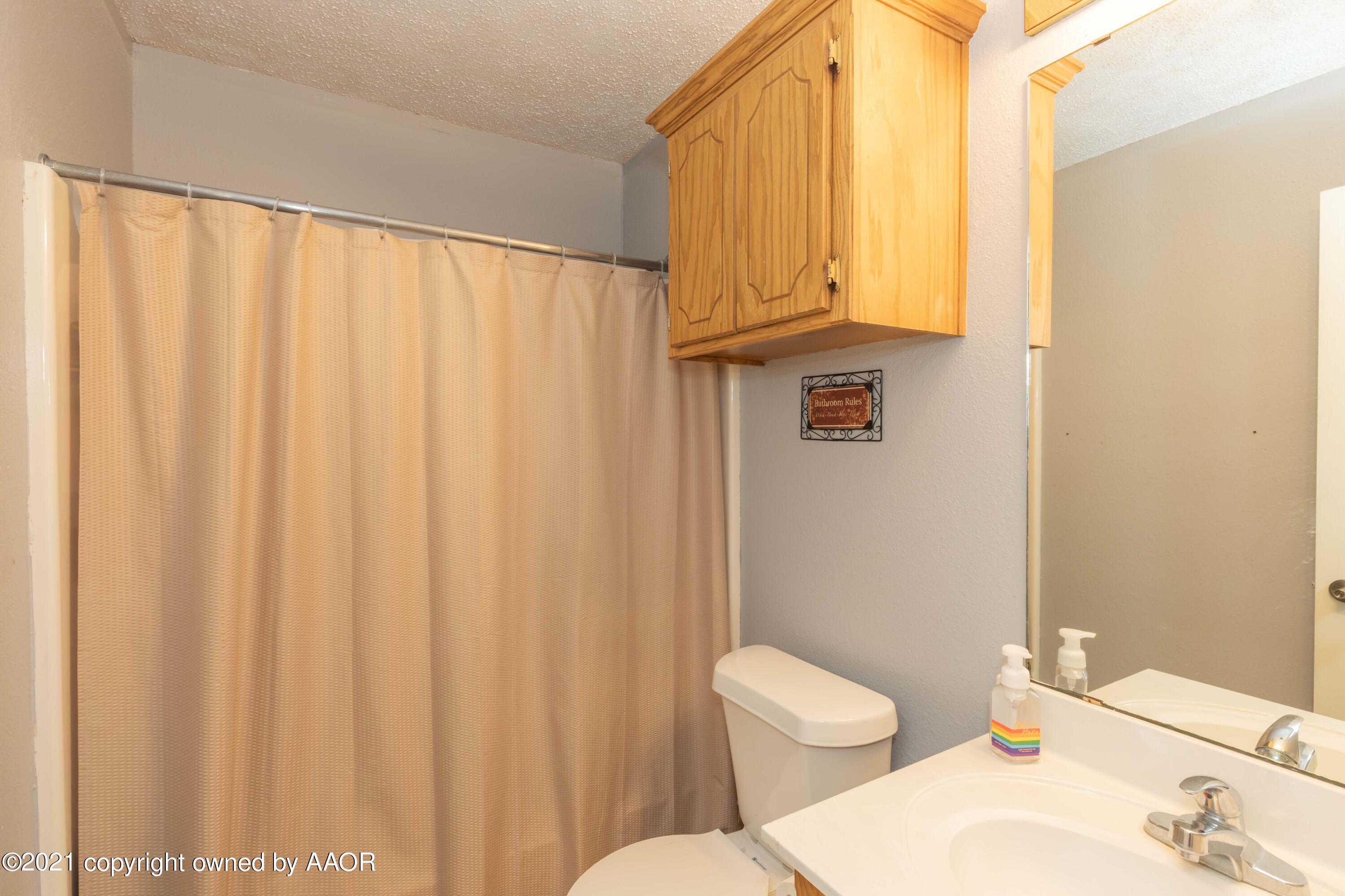 1025 Ketler Street Amarillo, TX 79104 - Photo 17 of 31 a white toilet sitting next to a shower curtain