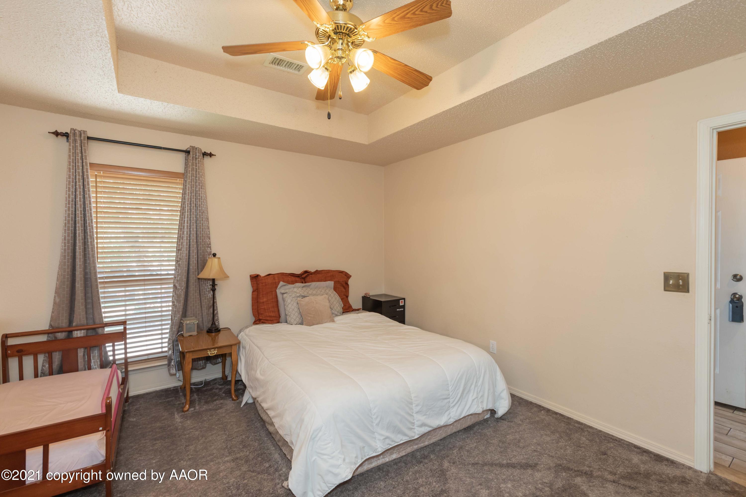 1025 Ketler Street Amarillo, TX 79104 - Photo 20 of 31 a bedroom with a bed and a chandelier