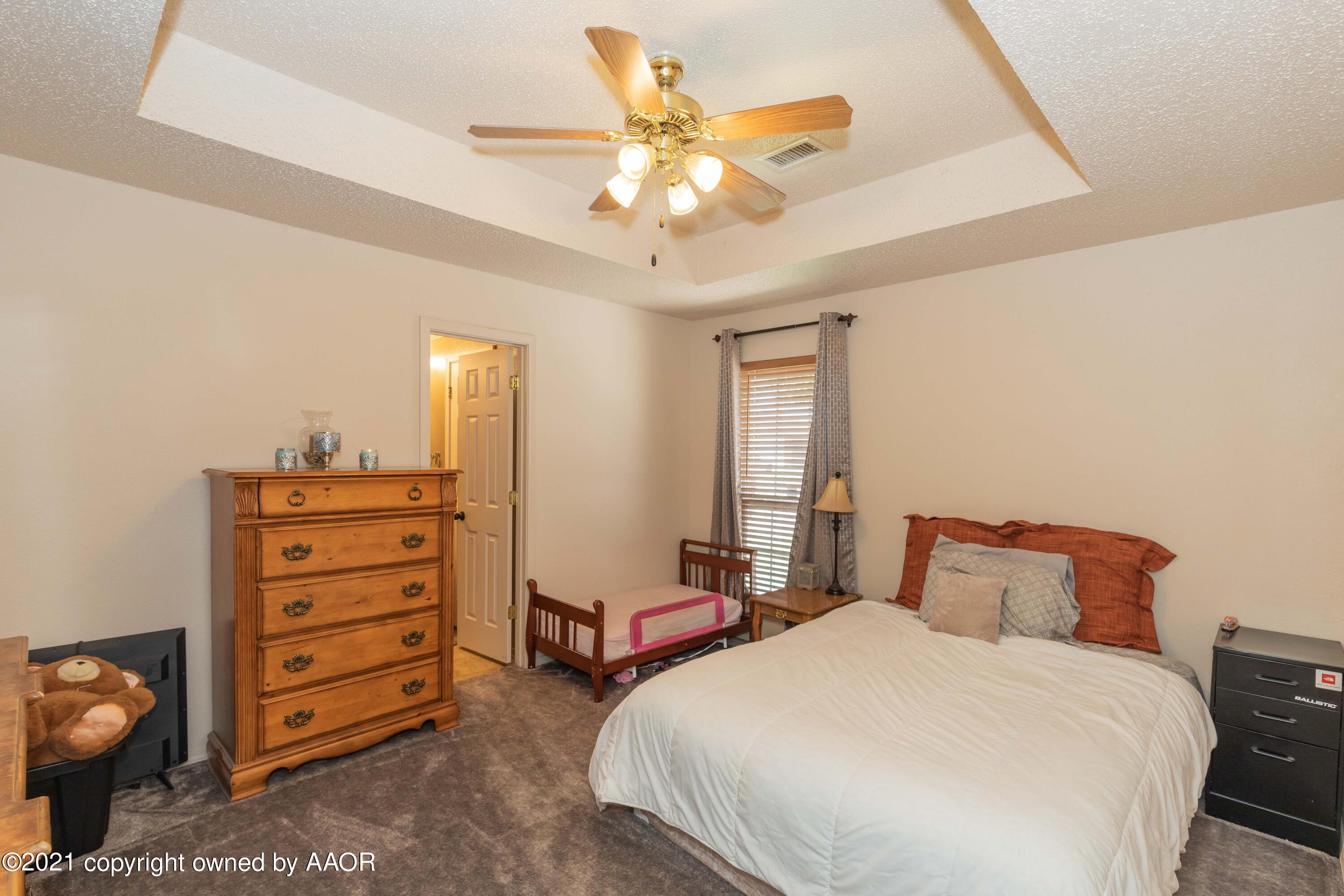 1025 Ketler Street Amarillo, TX 79104 - Photo 22 of 31 a bedroom with a bed and a chandelier