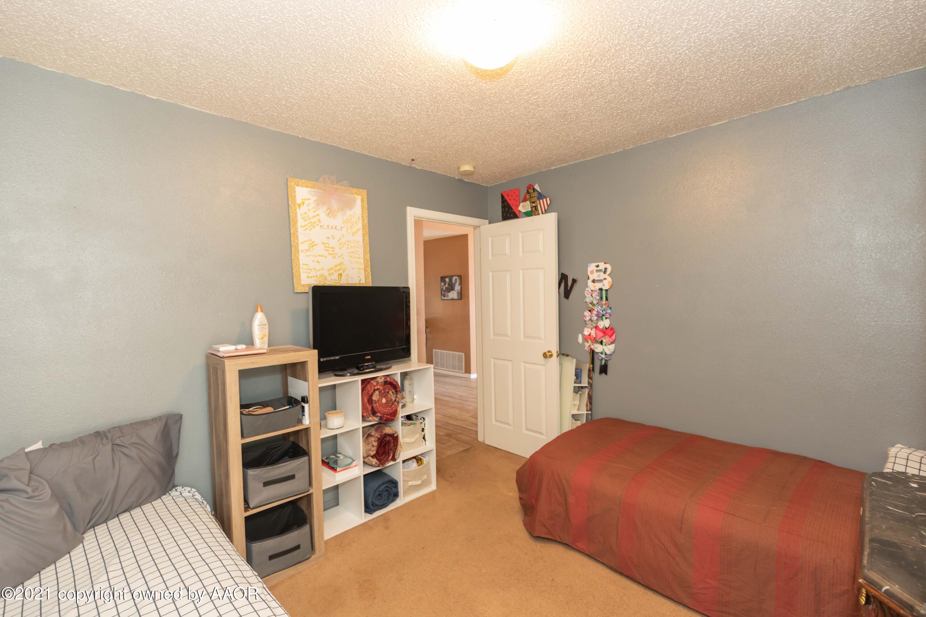 1025 Ketler Street Amarillo, TX 79104 - Photo 26 of 31 a bedroom with furniture and a flat screen tv