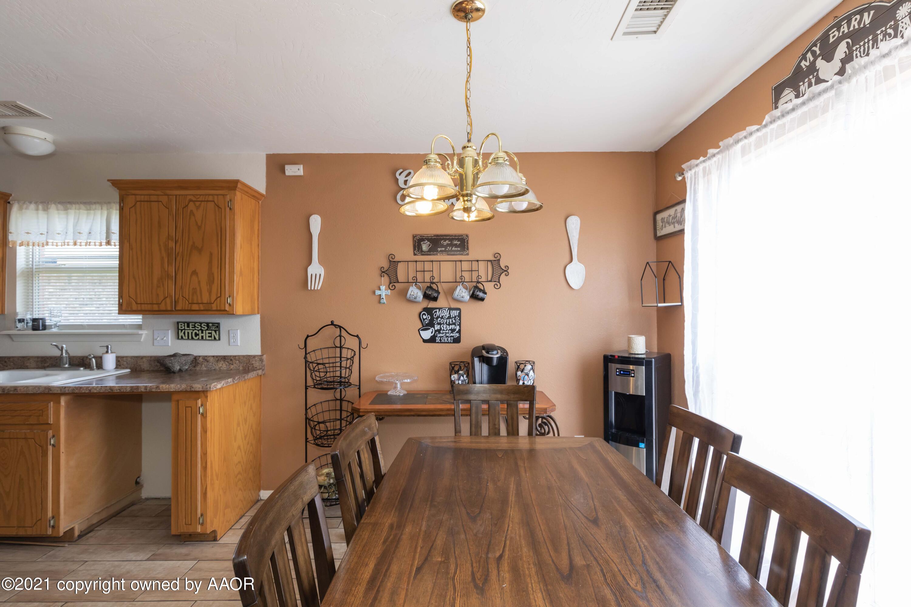 1025 Ketler Street Amarillo, TX 79104 - Photo 7 of 31 a dining room with furniture a chandelier and wooden floor