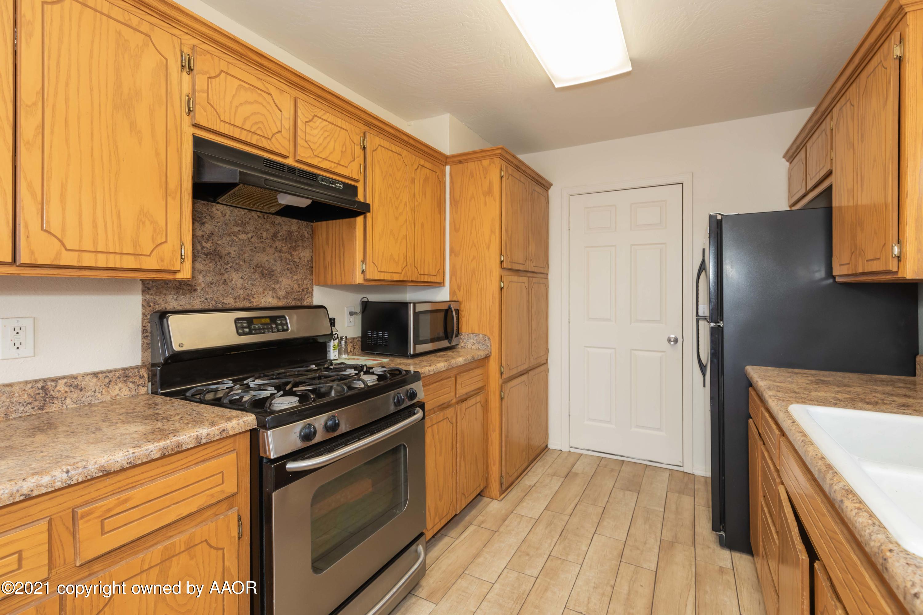 1025 Ketler Street Amarillo, TX 79104 - Photo 9 of 31 a kitchen with granite countertop a stove and a refrigerator