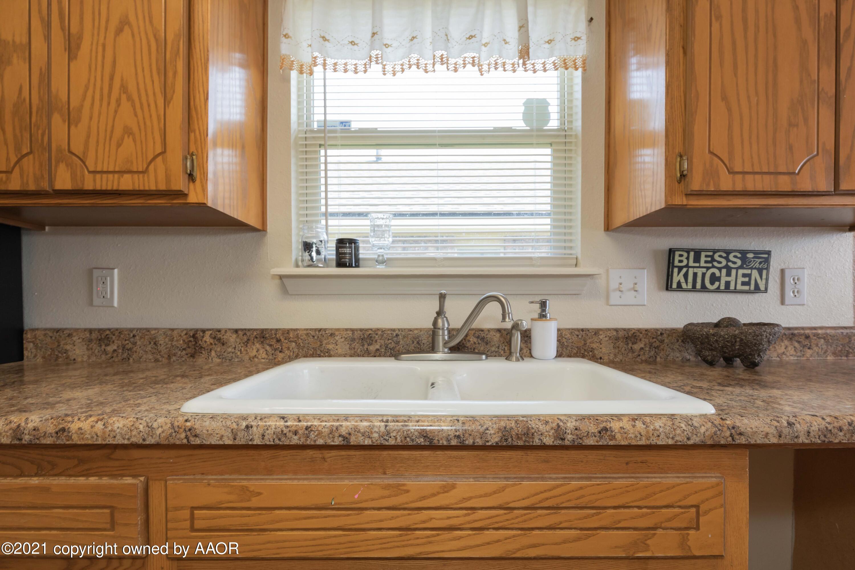 1025 Ketler Street Amarillo, TX 79104 - Photo 10 of 31 a kitchen with granite countertop granite countertop white cabinets and a sink