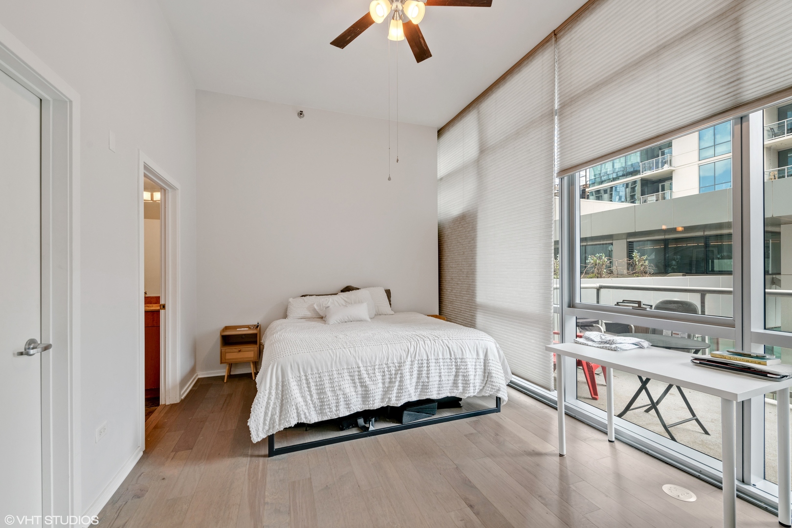 123 South Green Street, Unit 208B Chicago, IL 60607 - Photo 7 of 17 a bedroom with a bed and a chandelier