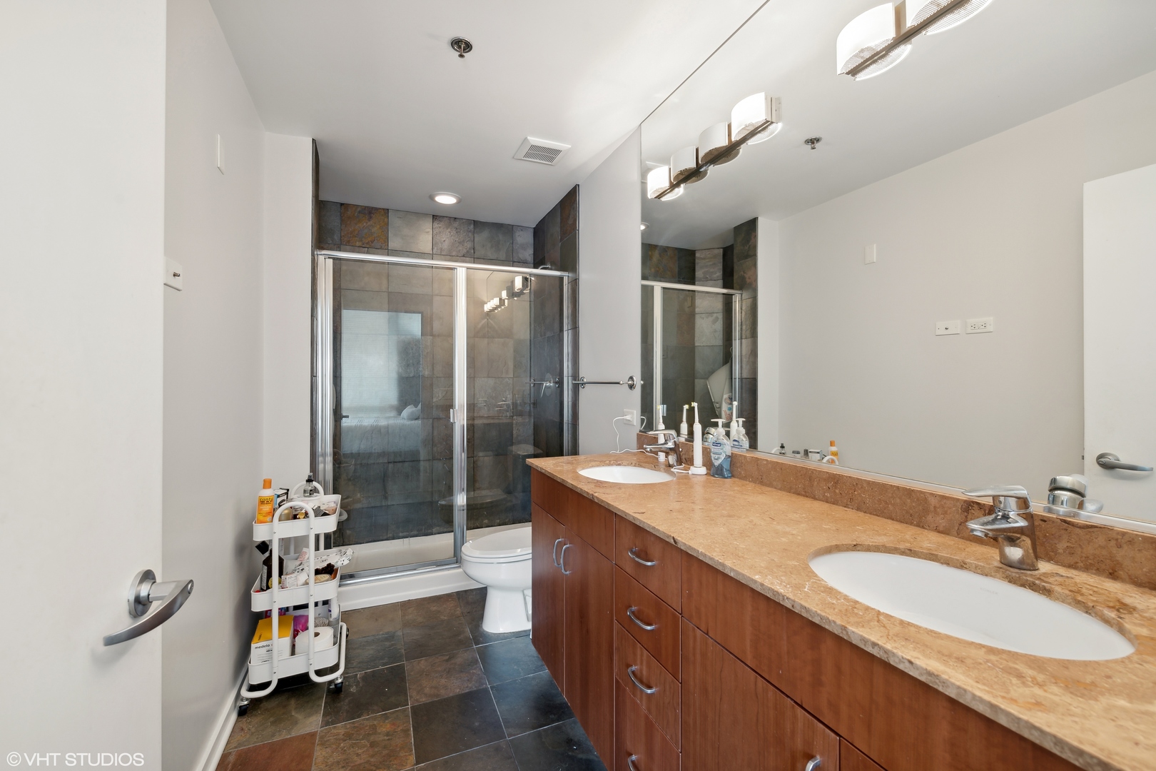 123 South Green Street, Unit 208B Chicago, IL 60607 - Photo 8 of 17 a spacious bathroom with a granite countertop sink a mirror and shower