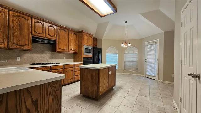 a kitchen with stainless steel appliances granite countertop a stove a sink and a microwave