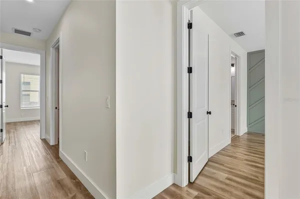 a view of a hallway with wooden floor and staircase