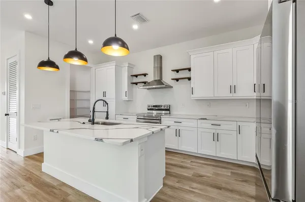 a kitchen with stainless steel appliances granite countertop a sink a stove and a refrigerator
