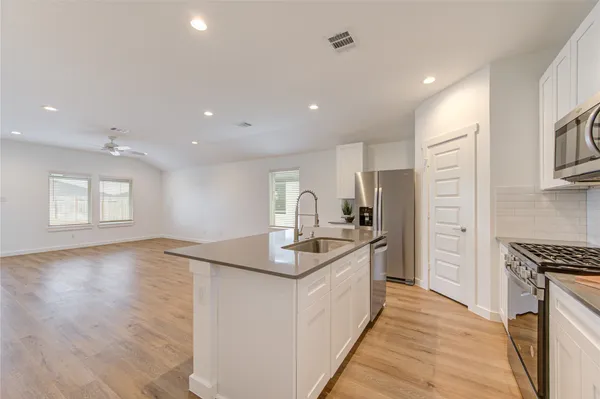 a kitchen with kitchen island granite countertop a sink and refrigerator
