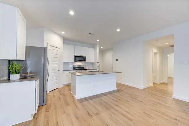 a kitchen with stainless steel appliances a refrigerator and a stove top oven