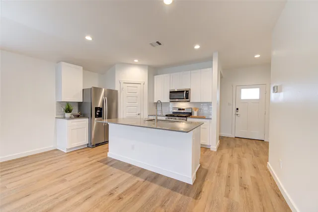 a kitchen with stainless steel appliances granite countertop a sink stove and refrigerator