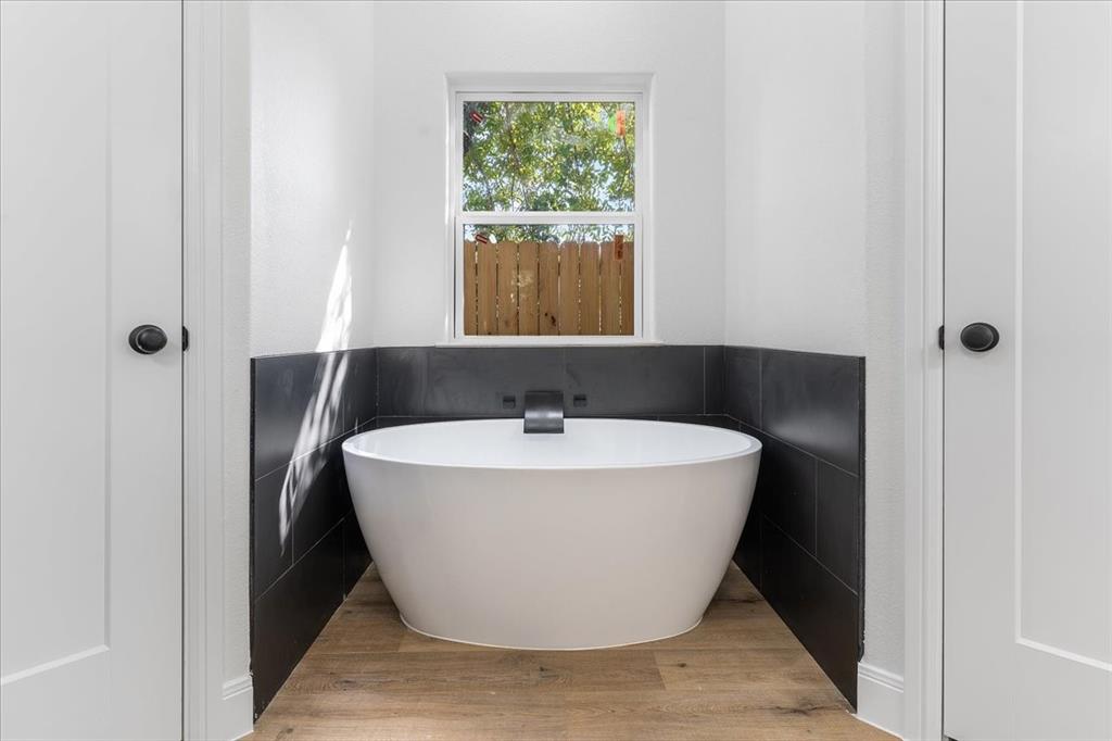 4715 Ramey Avenue Fort Worth, TX 76105 - Photo 20 of 32 a white bath tub sitting in a bathroom