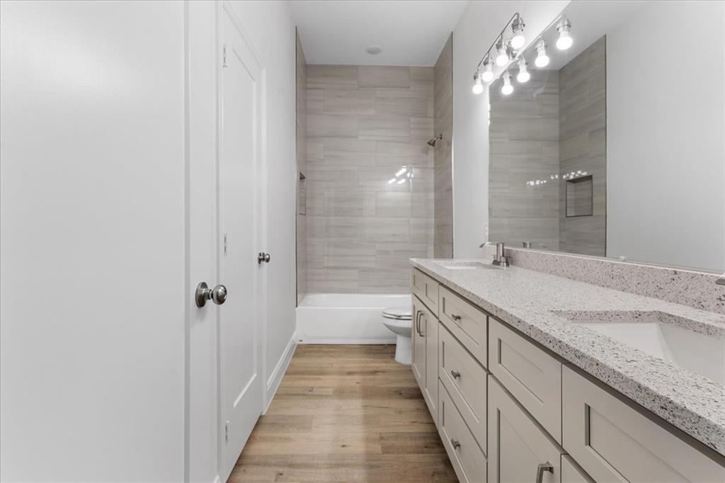 4715 Ramey Avenue Fort Worth, TX 76105 - Photo 24 of 32 a spacious bathroom with a granite countertop double vanity sink a mirror and a shower