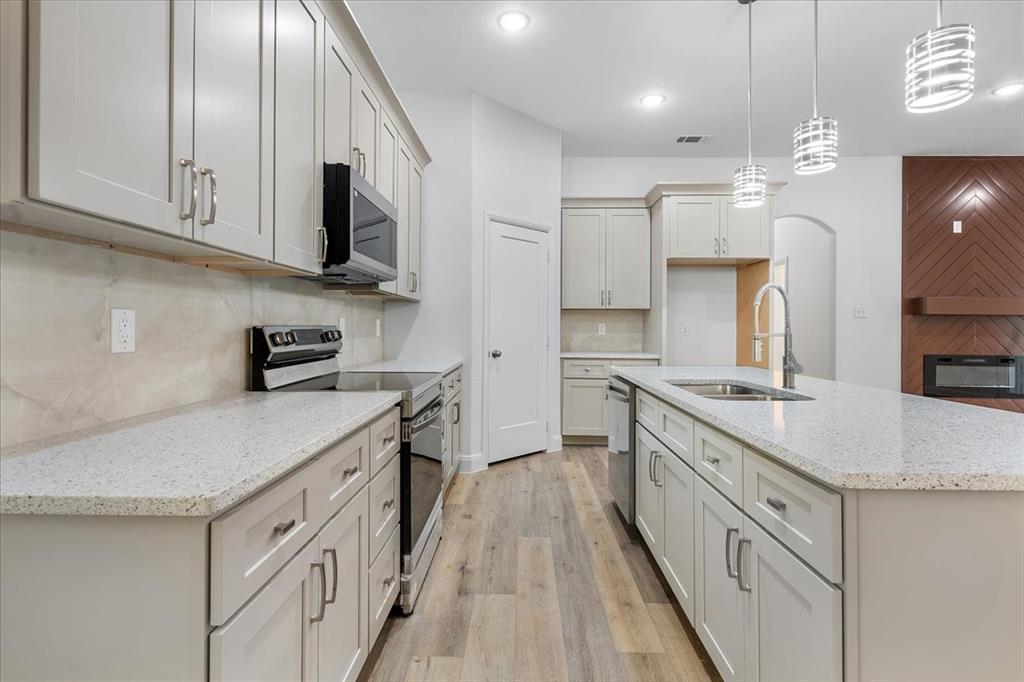 4715 Ramey Avenue Fort Worth, TX 76105 - Photo 9 of 32 a kitchen with stainless steel appliances granite countertop a sink a stove and a refrigerator
