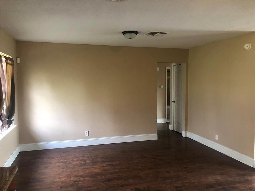 5631 Groveton Street Houston, TX 77033 - Photo 5 of 13 an empty room with wooden floor and windows