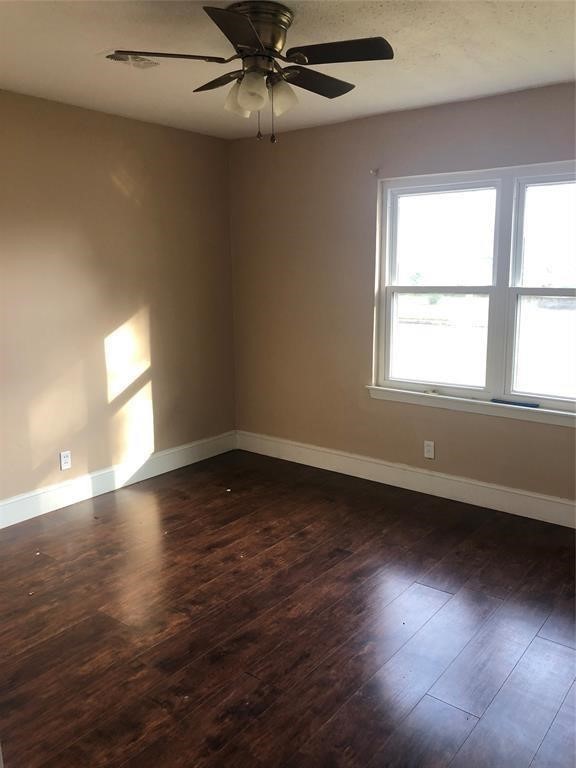 5631 Groveton Street Houston, TX 77033 - Photo 9 of 13 an empty room with wooden floor and windows