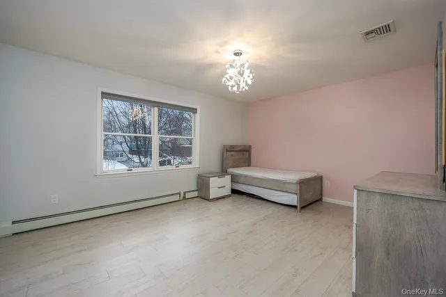 a spacious bedroom with a bed and a window