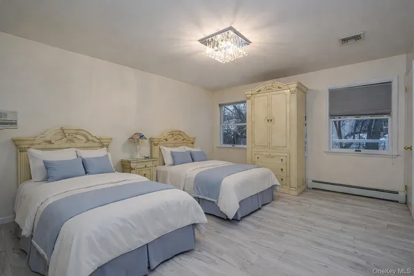 a bedroom with two beds and a chandelier