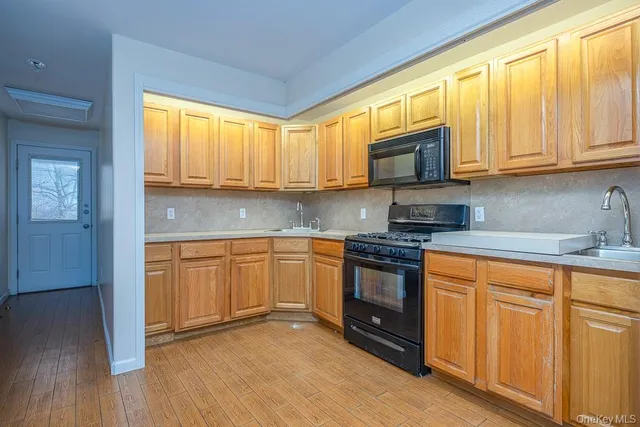 a kitchen with stainless steel appliances granite countertop wooden cabinets a sink and a stove
